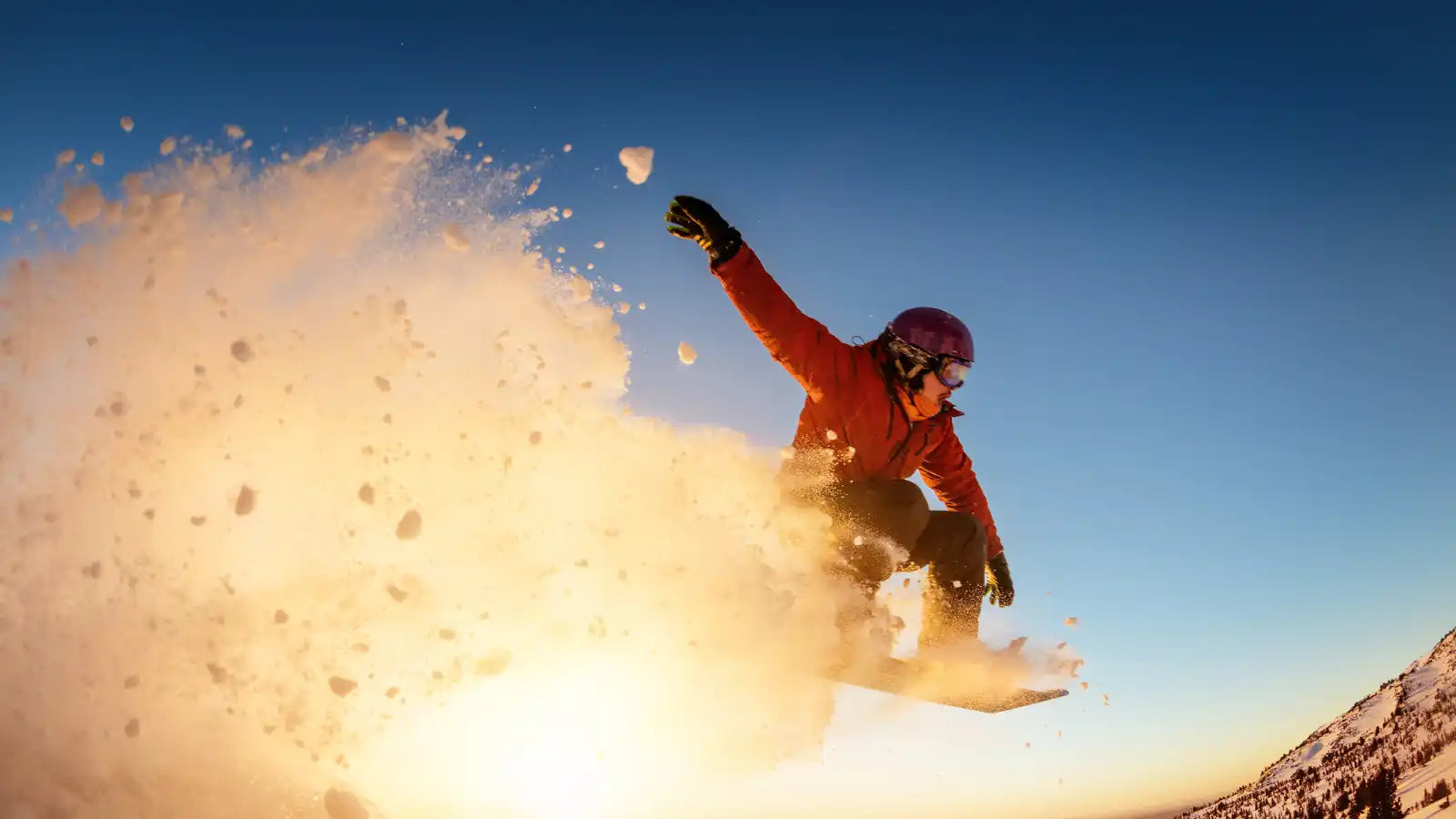Snowboarder in mid-air with a cloud of snow
